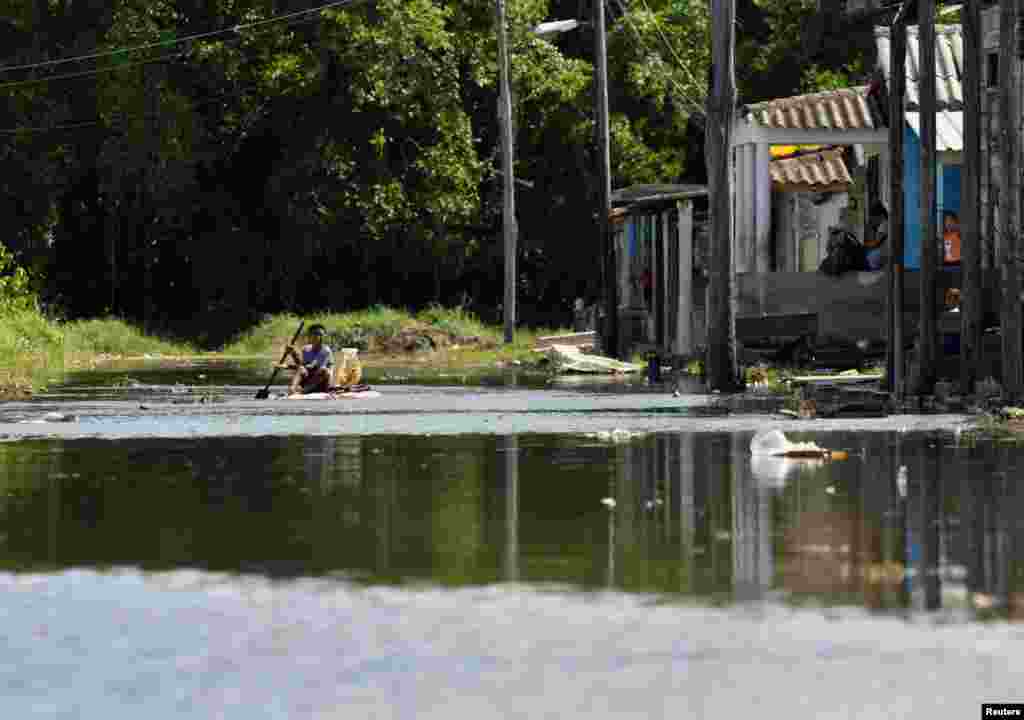 Un niño flota en una balsa improvisada en una calle inundada, en Batabanó, por efecto del acercamiento del huracán Milton a la costa occidental de Cuba. REUTERS/Norlys Pérez