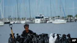 Susana Ortiz llena bolsas de arena en la playa de Davis Islands Yacht Basin mientras se prepara para la llegada del huracán Milton, el martes 8 de octubre de 2024, en Tampa, Florida. (Foto AP/Julio Cortez)